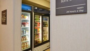 Ein Hotel-Suite-Shop mit täglichem 24-Stunden-Service und einer Kühlvitrine für Getränke und Snacks.