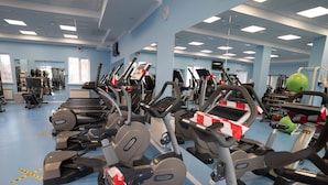 A gym with multiple treadmills and exercise equipment, a blue floor, and a mirrored wall. - Chagala Aksai (Aksay)