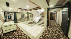 A hotel lobby with a check-in counter, a staircase, and a patterned floor. - Hotel Mostar (Mostar)