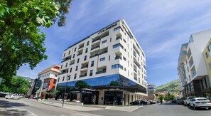 Un hôtel à plusieurs étages doté d’une façade moderne, de balcons et d’un restaurant situé au rez-de-chaussée.