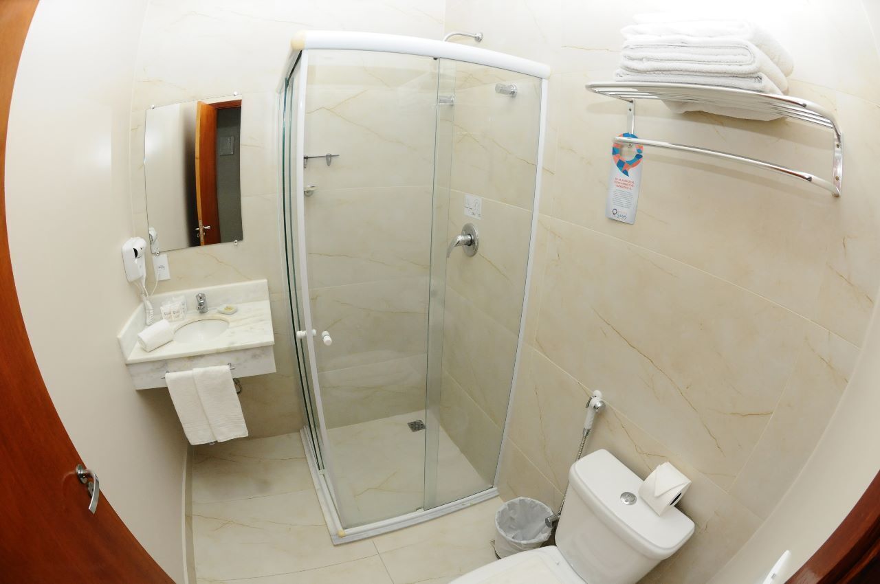 Une salle de bain moderne avec une douche à parois de verre, un lavabo avec un miroir et des toilettes.