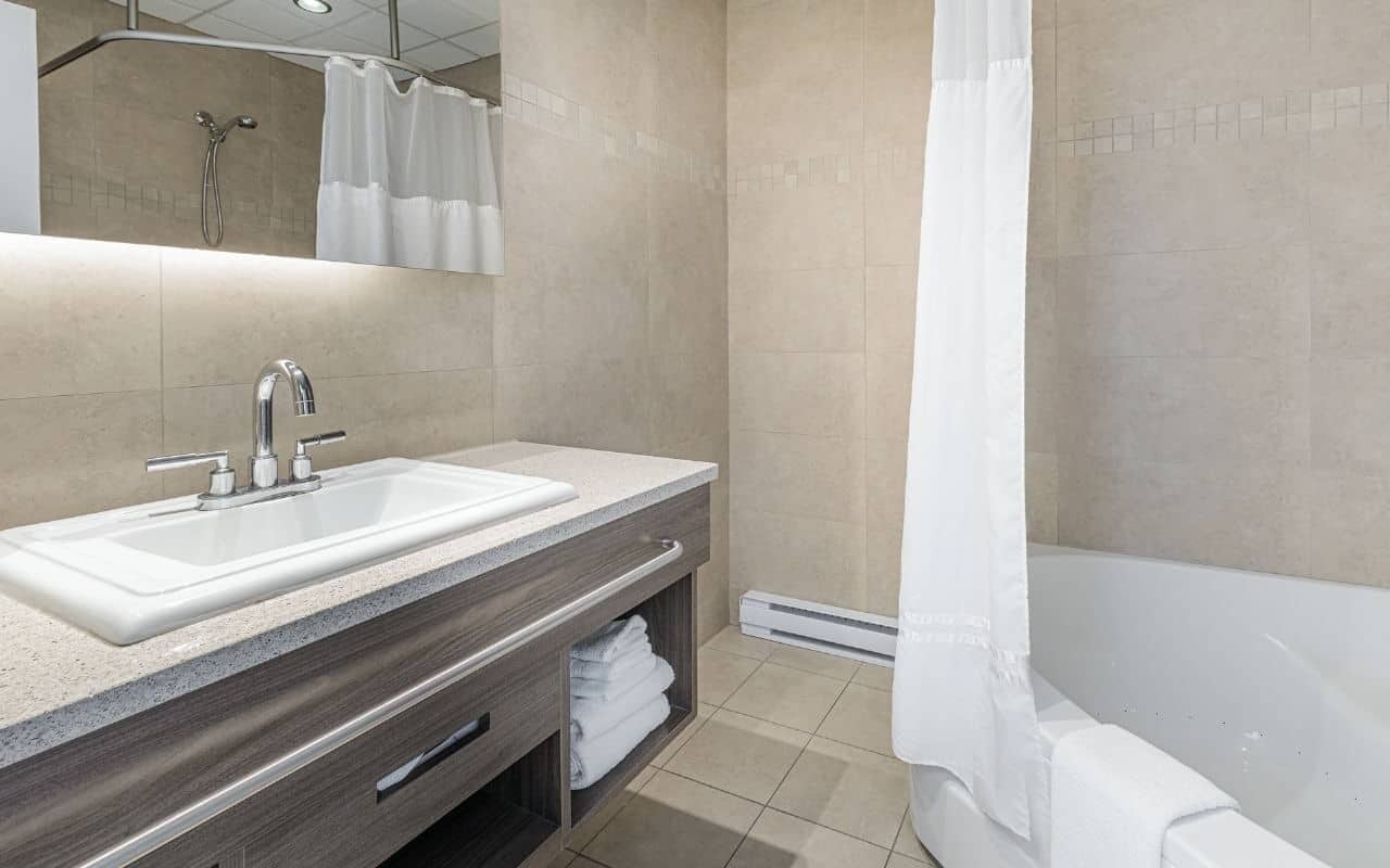 A modern bathroom with two sinks, a shower, and a bathtub.