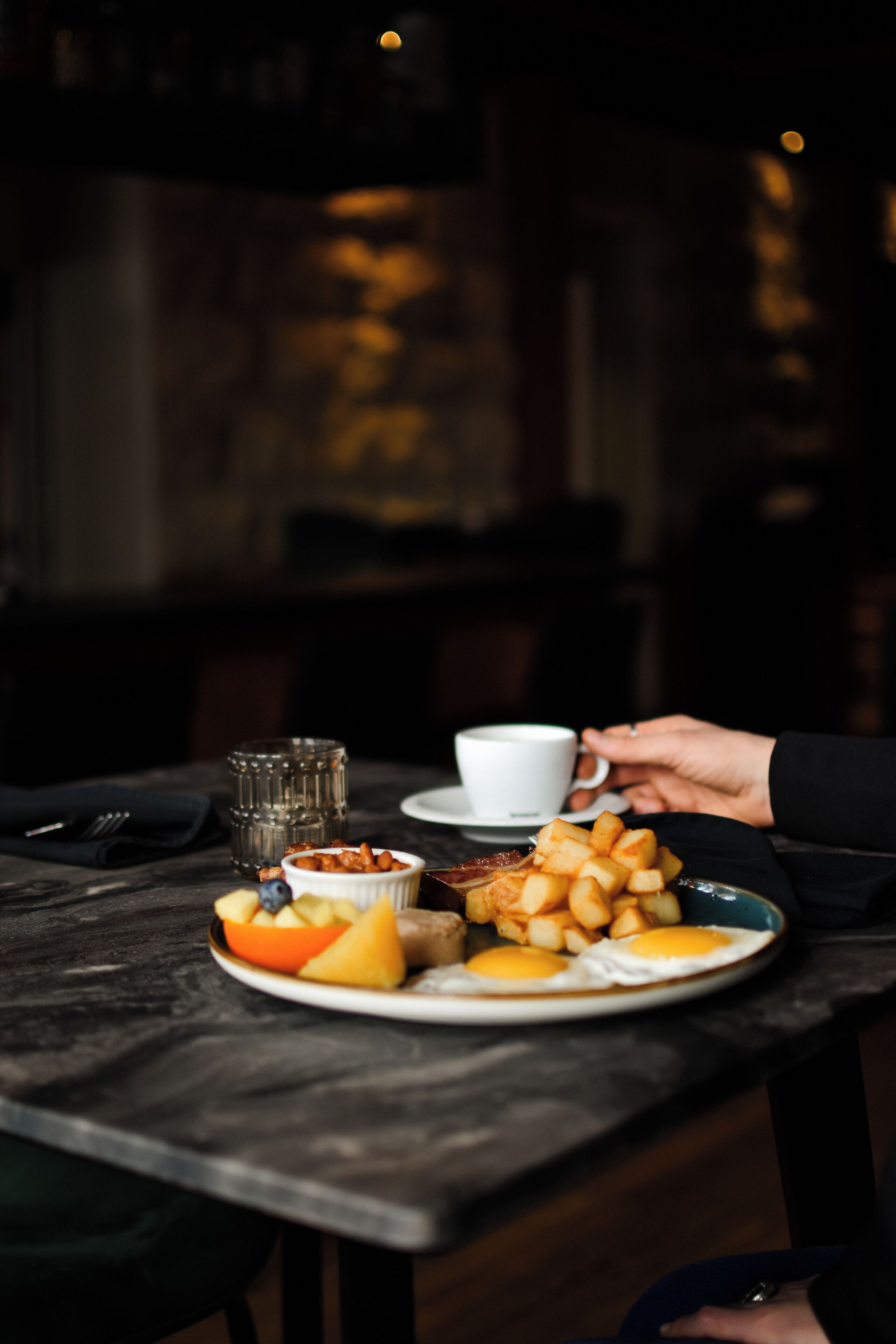 A dining table with plates of food, a cup, and a glass.