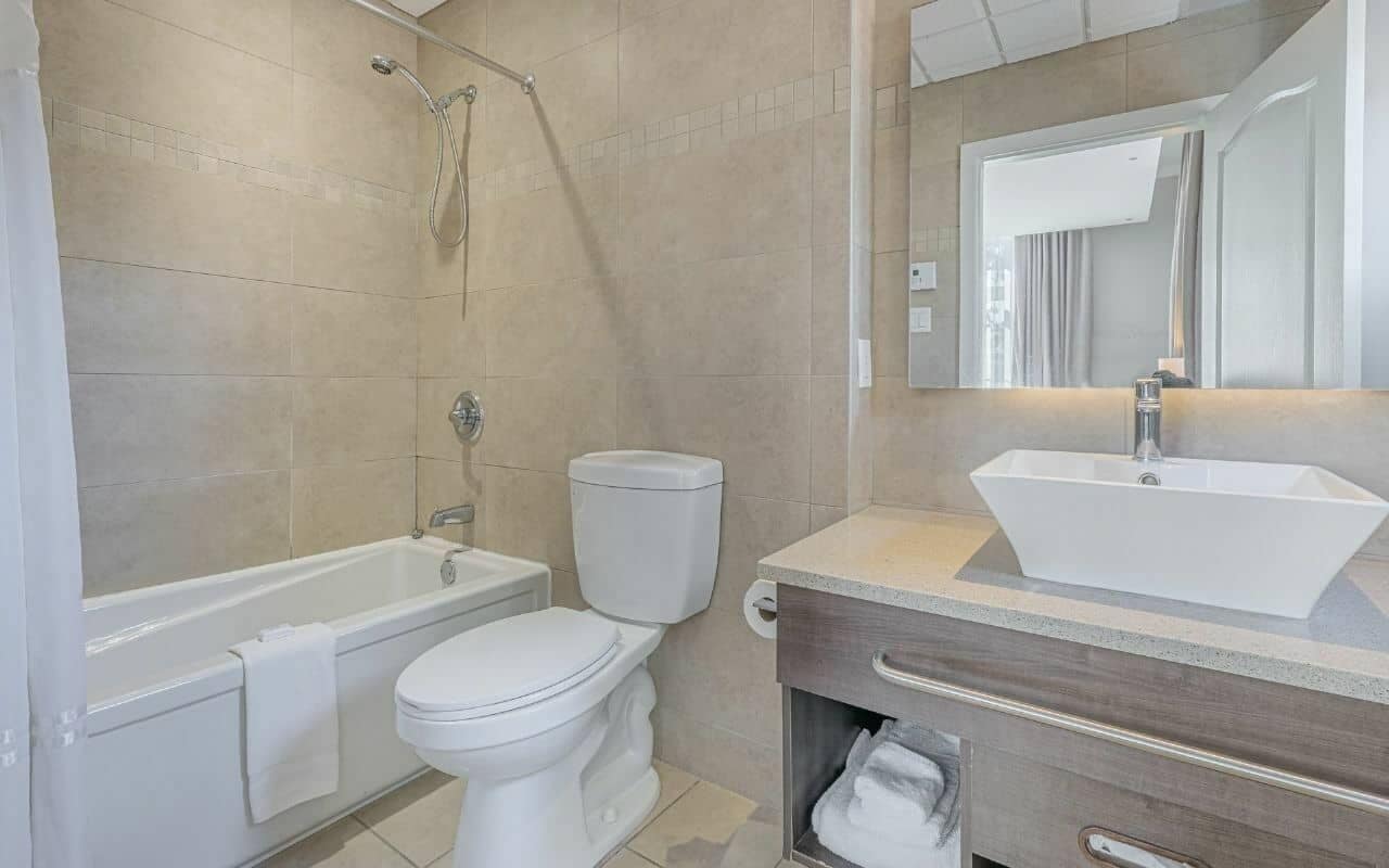 A modern bathroom with a bathtub, toilet, and sink.