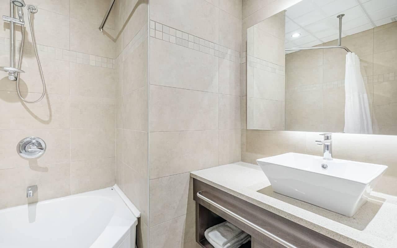 A modern bathroom with a bathtub, a shower, and a sink.