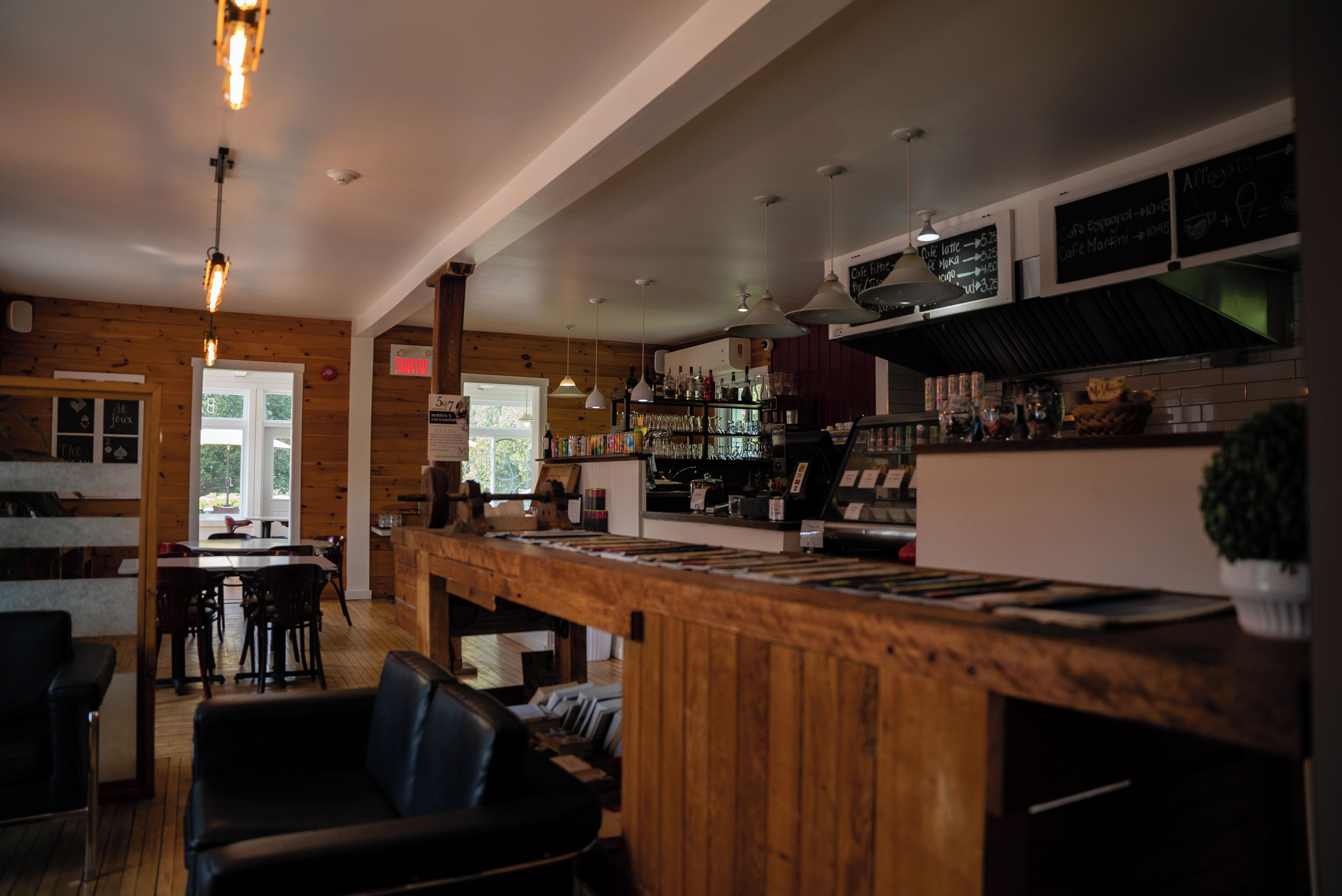 A restaurant with a wooden interior, a bar area, and a seating section.