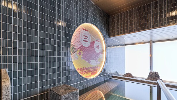 Un intérieur moderne avec un mur recouvert de carreaux, un élément décoratif circulaire et une vue sur une piscine.