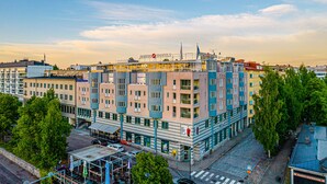 Un hôtel à plusieurs étages doté d’une architecture moderne, avec des balcons et une terrasse sur le toit.