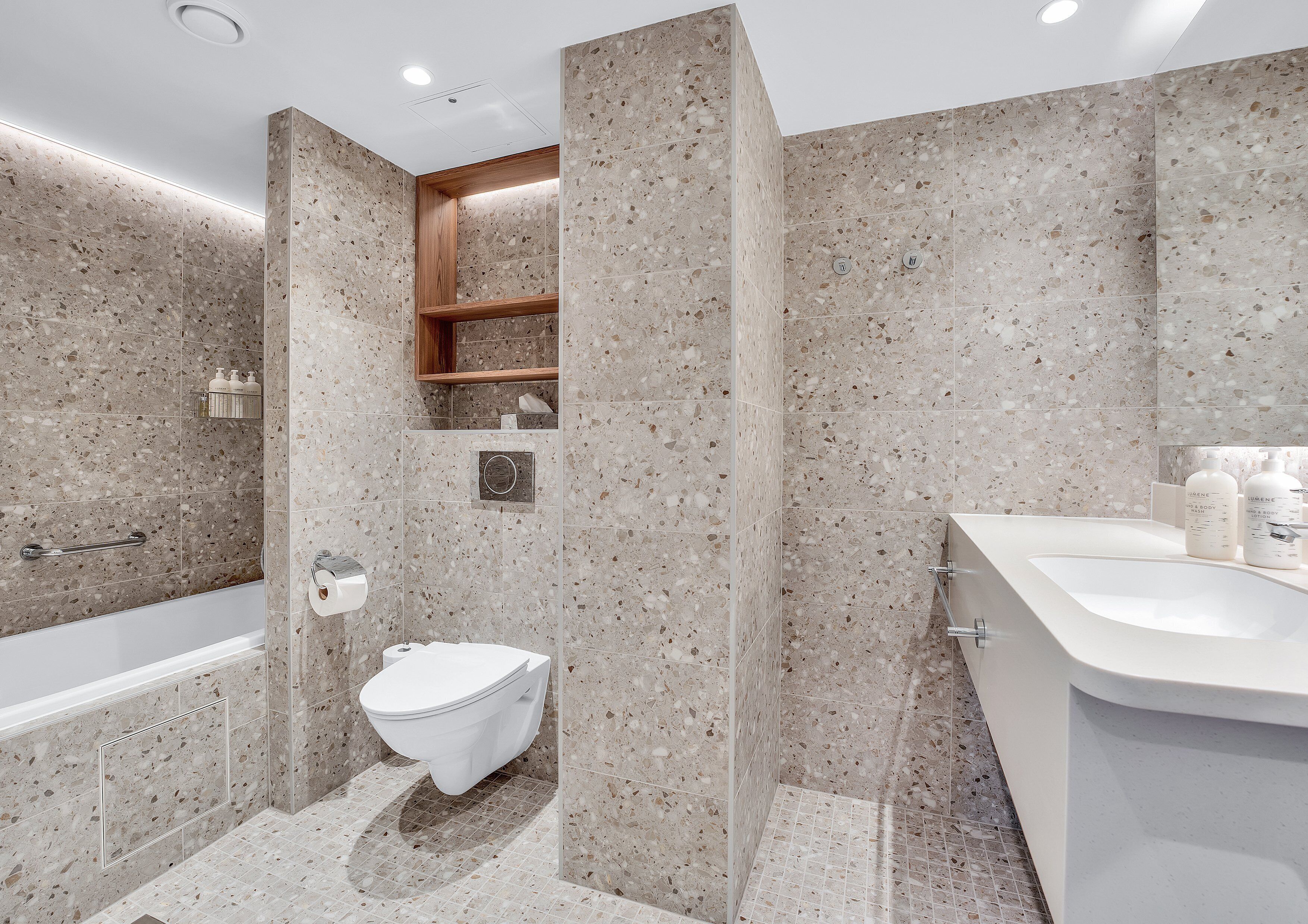 Een moderne badkamer met een vrijstaand bad, toilet en een wastafelmeubel met een wastafel.