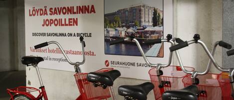 A bicycle rental station with red bicycles and baskets.
