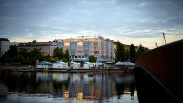 A waterfront hotel with multiple buildings, a dock, and a reflection in the water.