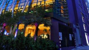 A modern high-rise building with reflective glass windows and a prominent entrance with a staircase. - Mode Sathorn Hotel (Bangkok)