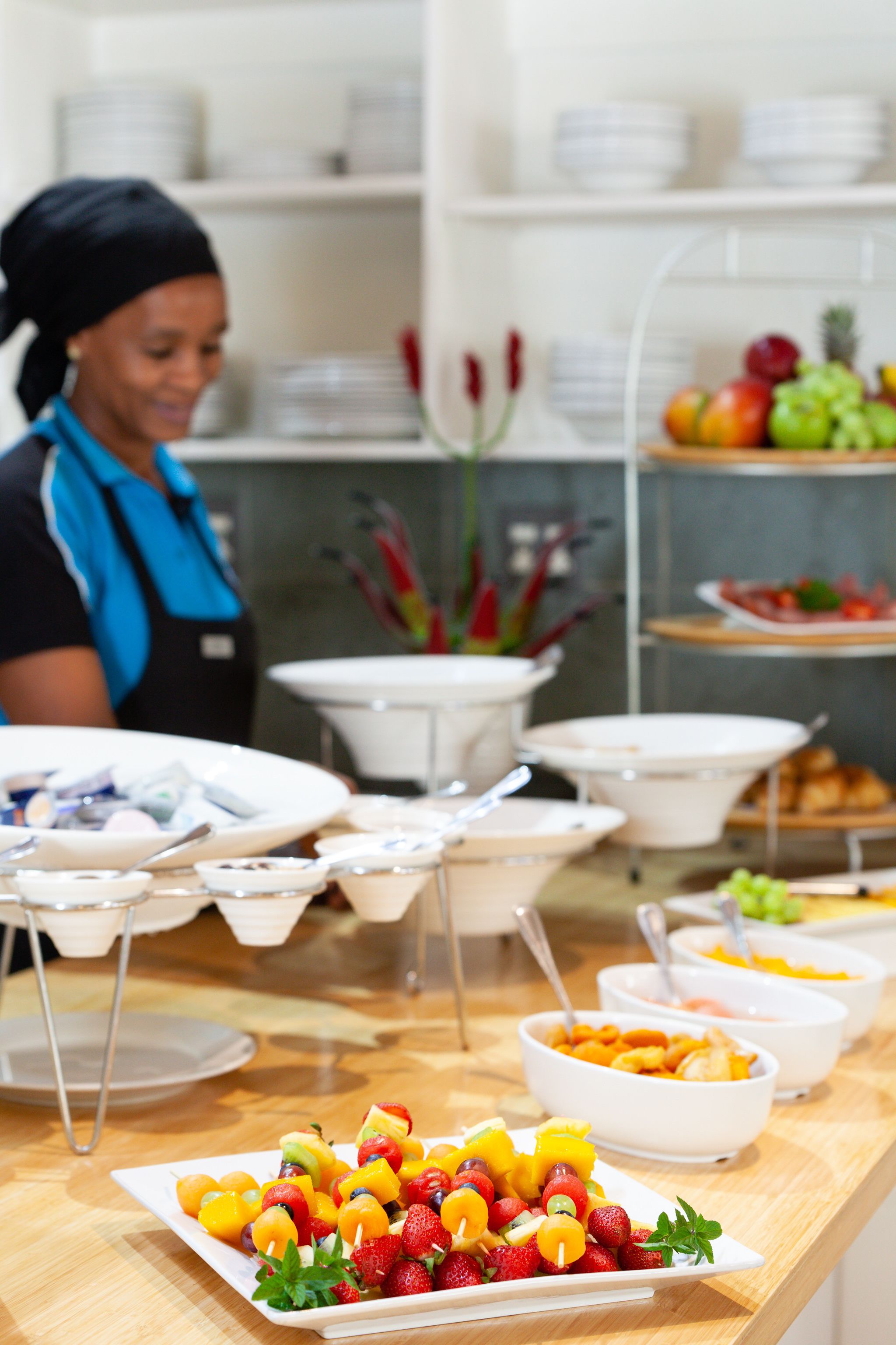 Een buffetopstelling met diverse gerechten en een persoon op de achtergrond.