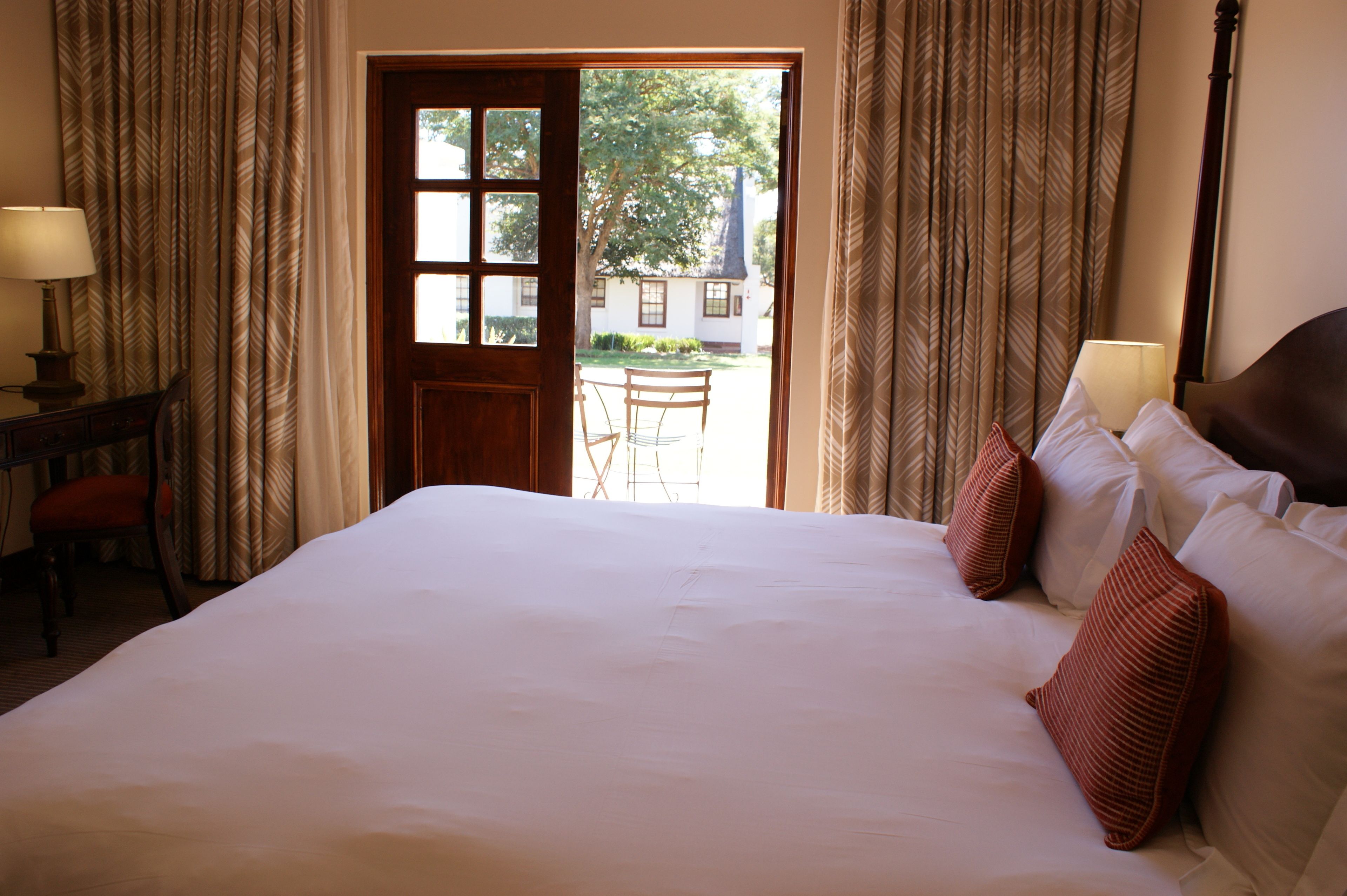Una habitación de hotel con una cama grande, un escritorio con una silla y vistas al exterior.