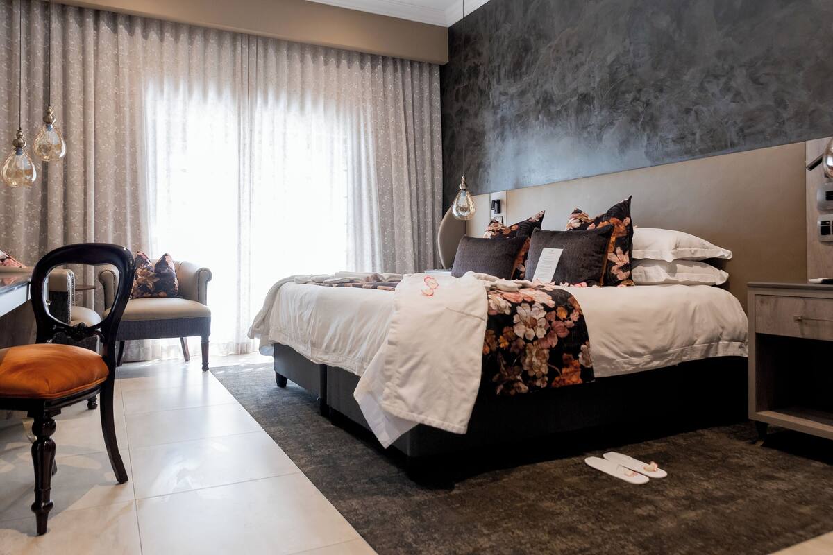 Un dormitorio moderno con una cama grande, un escritorio y una silla.
