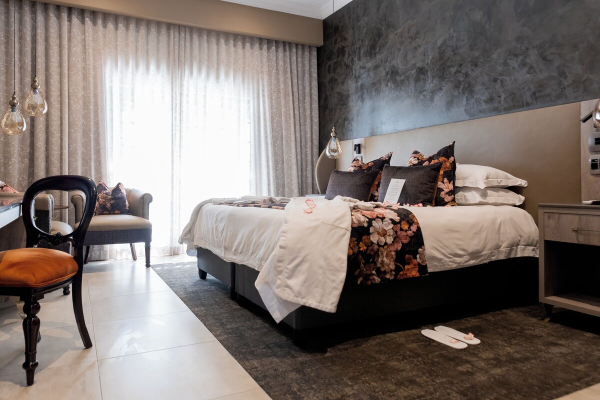 Une chambre à coucher moderne avec un grand lit, un bureau et une chaise.