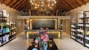 A spacious lobby with a high ceiling, a central chandelier, and a reception desk.