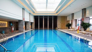 An indoor swimming pool with clear blue water, a skylight ceiling, and lounge chairs along the sides. - Intercontinental Changzhou by IHG (Changzhou)