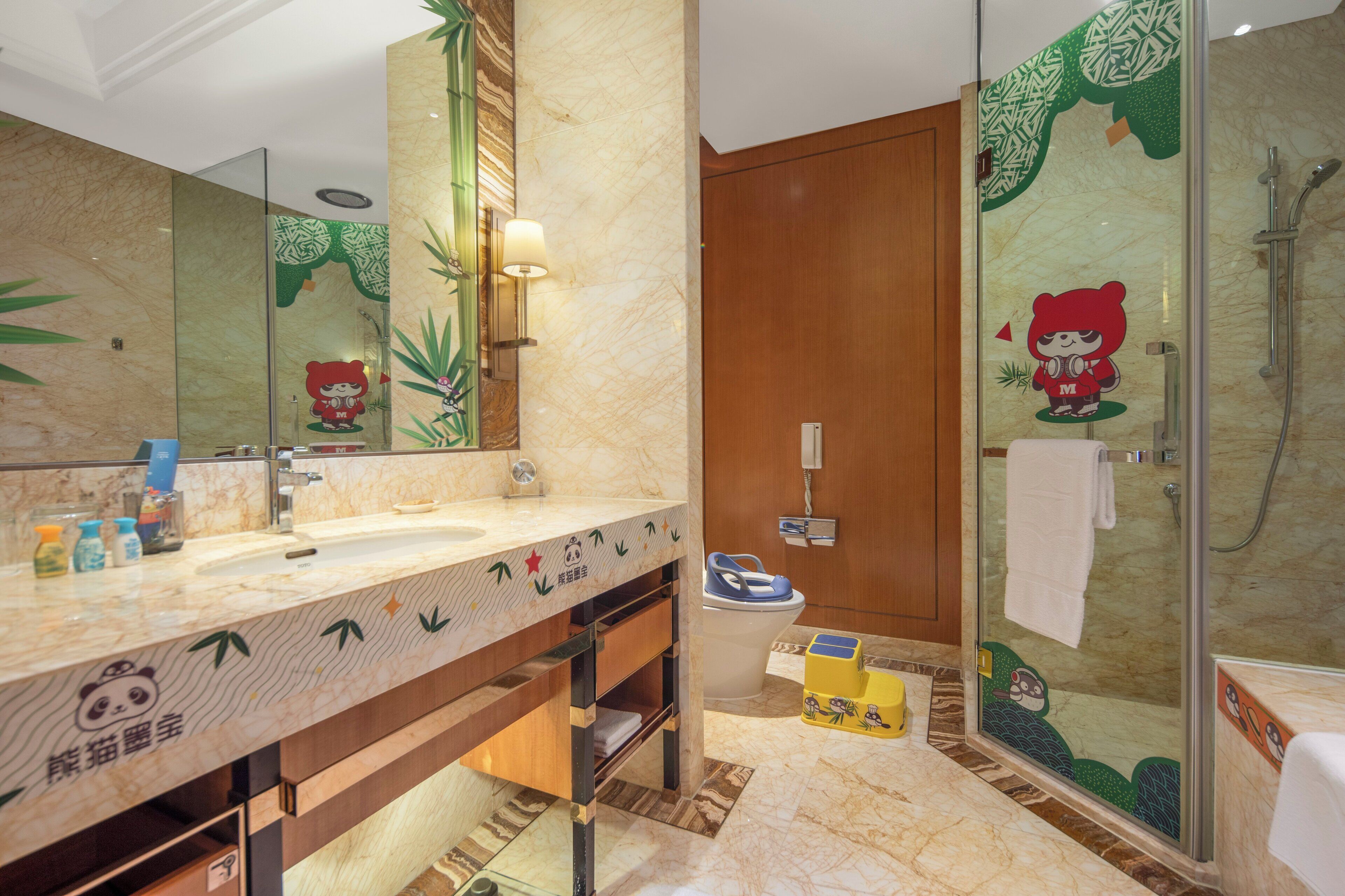 Ein Badezimmer mit Marmorwaschbecken, einer Duschkabine aus Glas und einer Toilette.