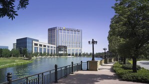 A riverside walkway with a modern building in the background. - Intercontinental Changzhou by IHG (Changzhou)