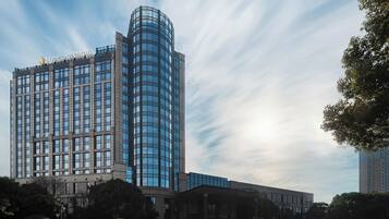 Un hotel moderno con fachada de vidrio curvo y estructura de base clásica.