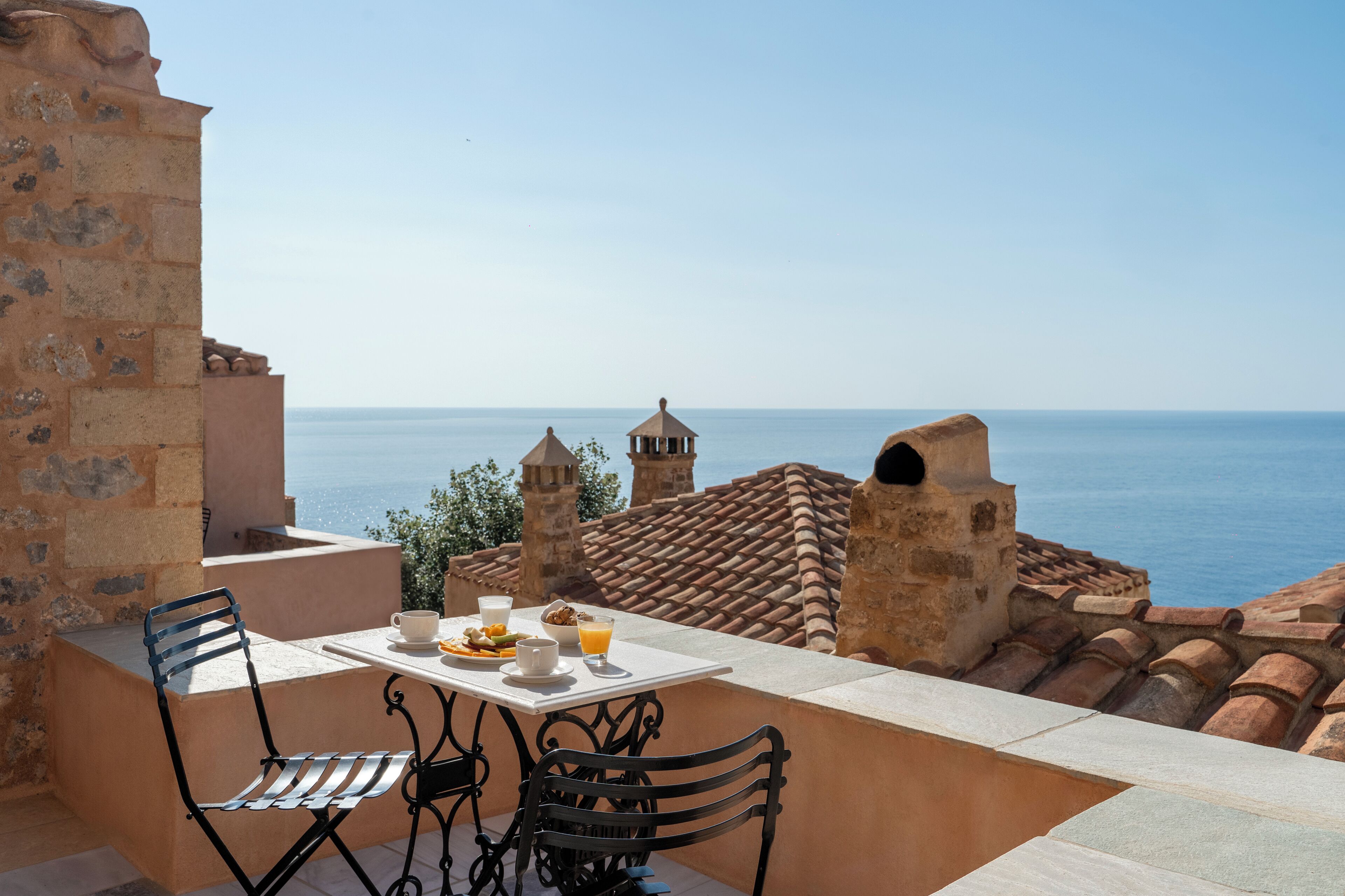 Una terraza con una mesa dispuesta para el desayuno y vistas al mar.