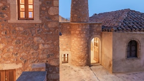 Un bâtiment en pierre doté d’une tour, d’une fenêtre et d’une porte ouverte.