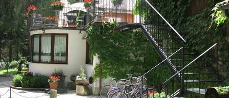 Un immeuble doté d’un balcon, de plantes en pot et de vélos.