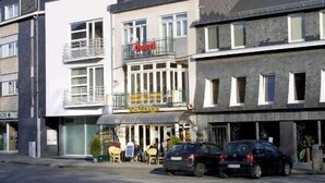 Un hotel con balcón, mobiliario exterior y un cartel que dice "Hotel".