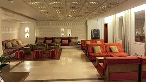 A spacious lobby with patterned walls, multiple seating areas, and a modern ceiling design. - K108 Hotel (Doha)