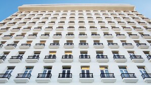 A high-rise building with a uniform facade, featuring numerous balconies and a prominent 'K 108' sign. - K108 Hotel (Doha)