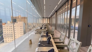 A restaurant with a long table set for dining, large windows offering a city view, and a modern interior design. - K108 Hotel (Doha)
