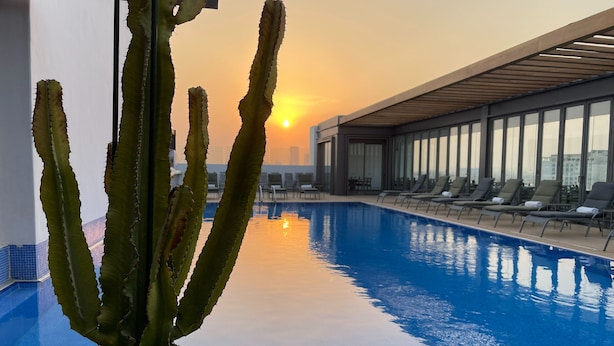 A rooftop pool with sunbathing chairs and a cactus in the foreground. - K108 Hotel (Doha)