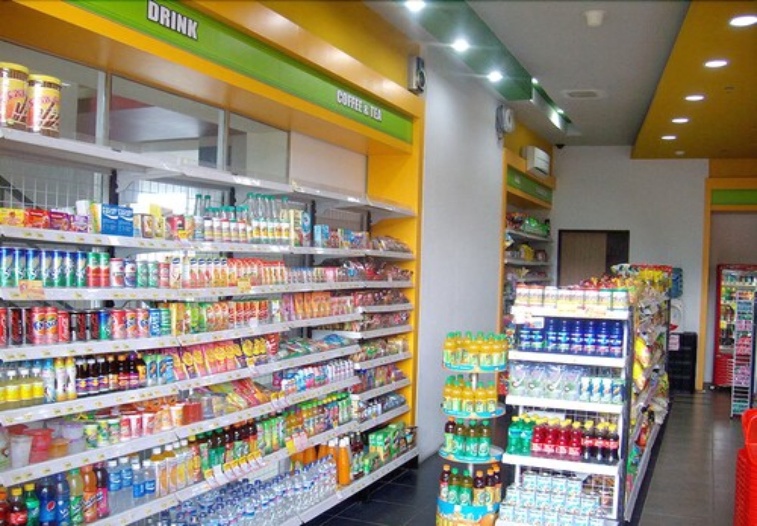 Un pasillo de un supermercado con estantes llenos de diversas bebidas y aperitivos.