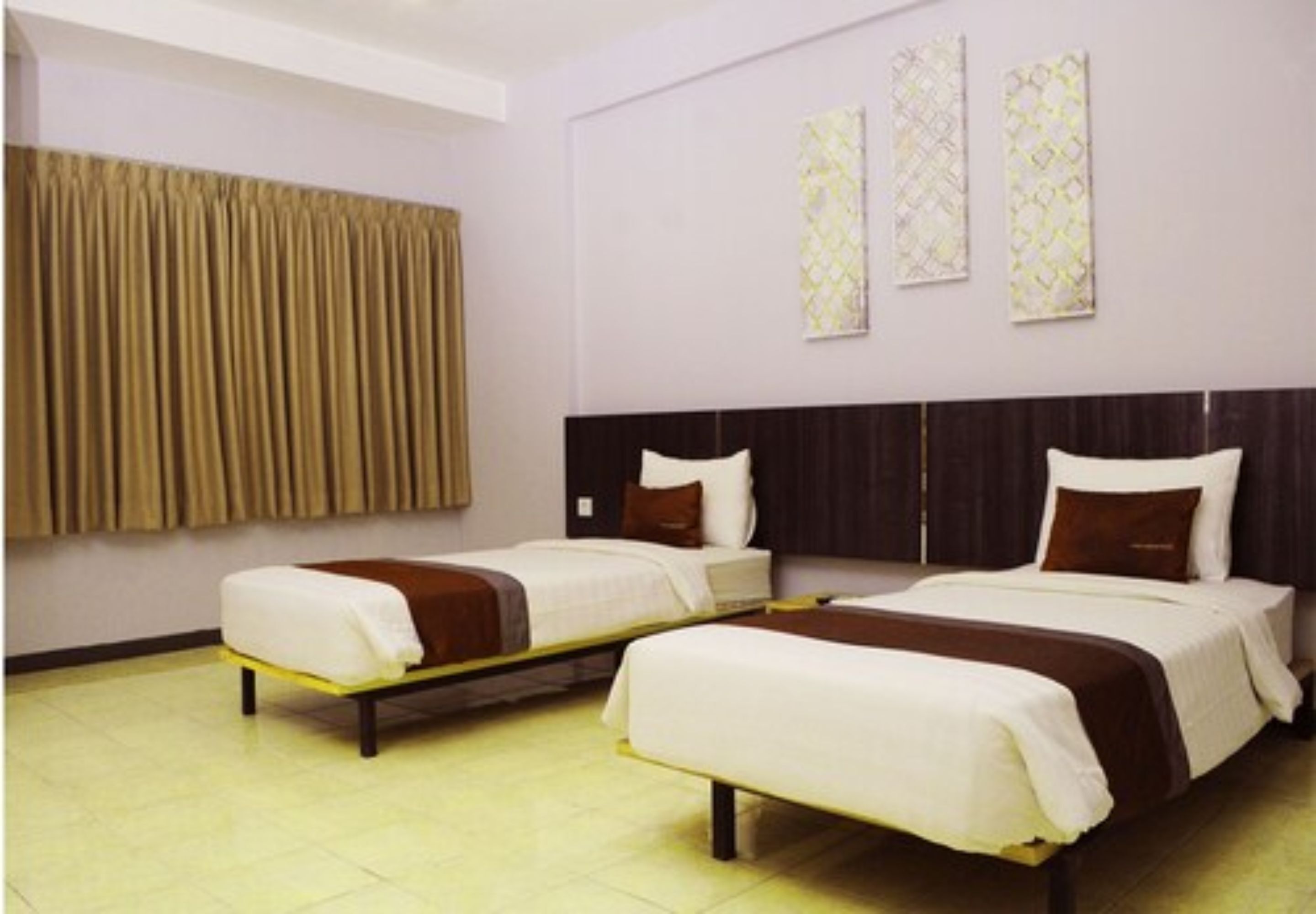 A hotel room with two single beds, a large window with curtains, and three patterned wall decorations.