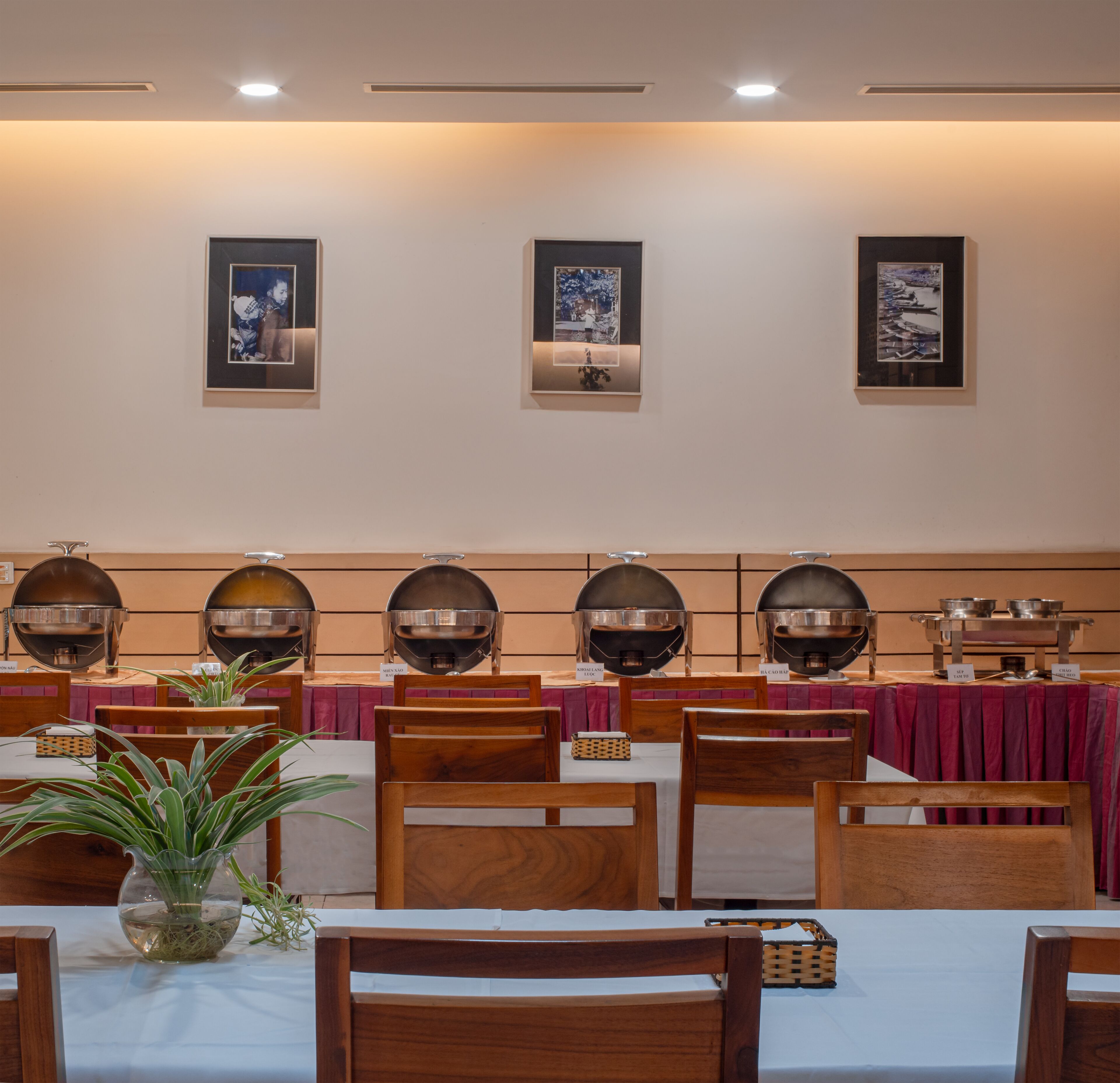 A dining area with multiple tables, chairs, and a buffet setup.