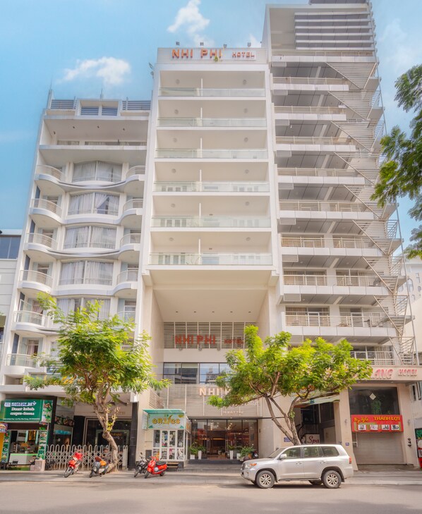Un hotel de varios pisos con balcones, entrada a nivel de calle y un spa visible.