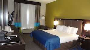 A hotel room with a bed, bedside tables, a desk, a chair, a desk lamp, a telephone, and a window with curtains. - Holiday Inn Express Hotel & Suites El Reno by IHG (El Reno)