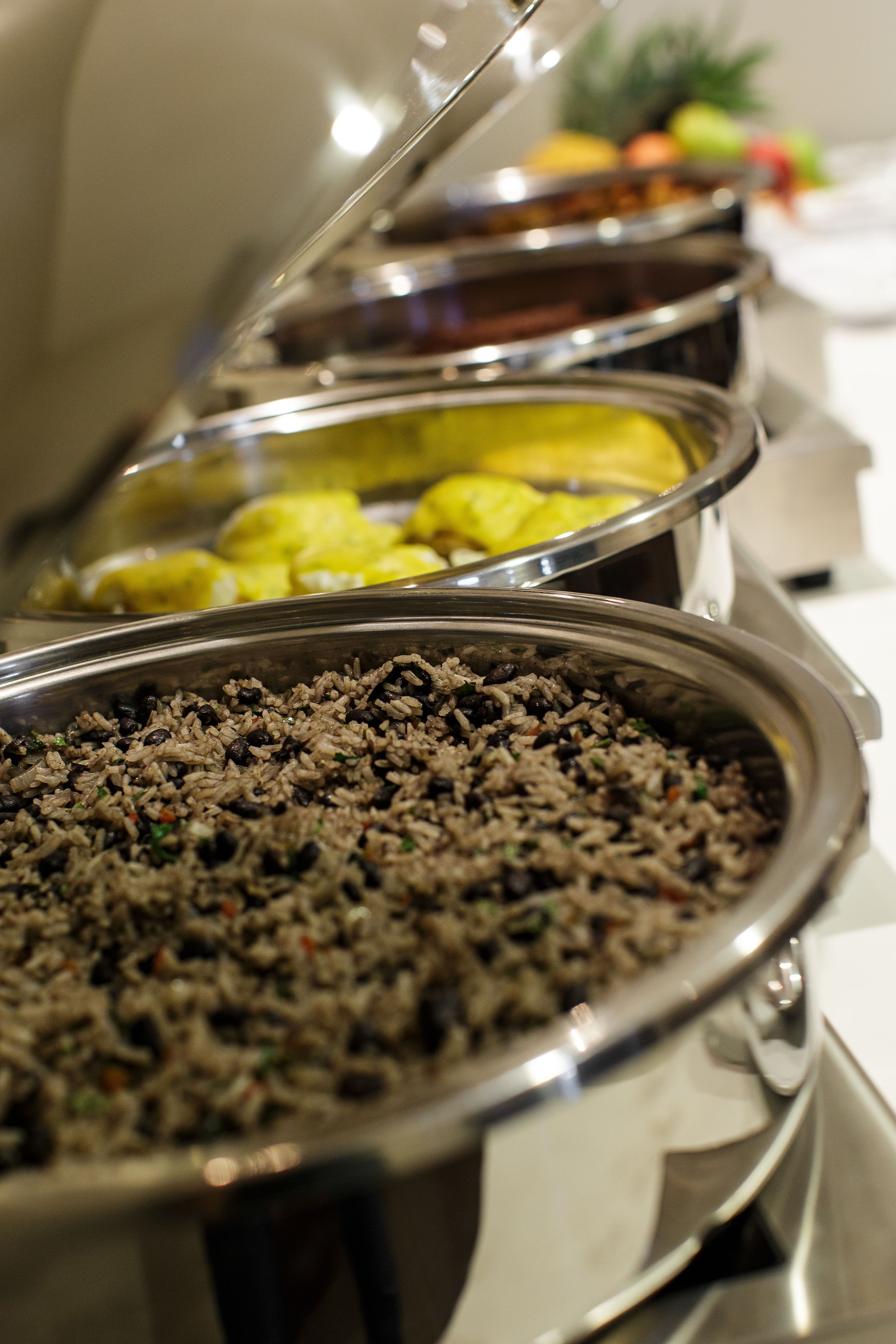 Un bufé con diversos platos, incluyendo arroz y alimentos amarillos.