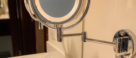 A bathroom vanity with a mirror, towel rack, and toiletries.
