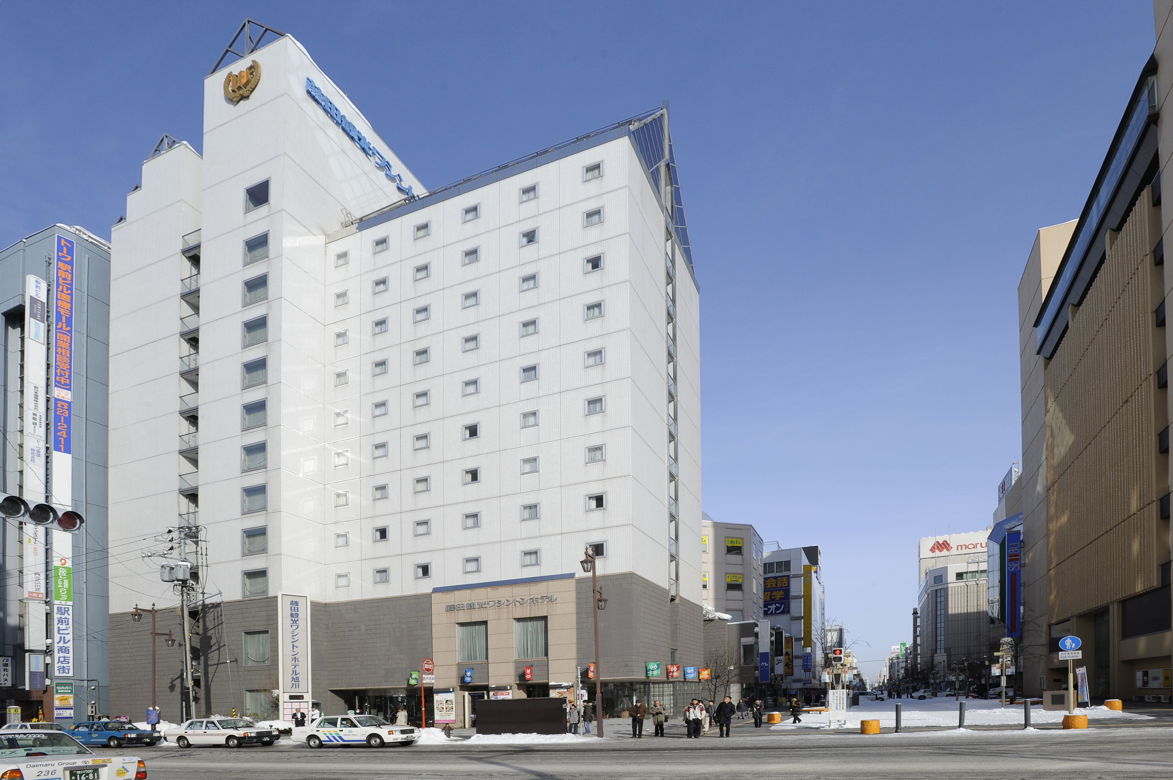 A multi-story hotel with a modern design, featuring a prominent entrance and several windows.