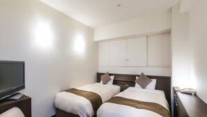 A hotel room with two beds, a TV, a small round table, and a desk with a phone.