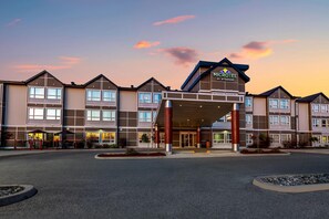 Ein mehrstöckiges Hotel mit markantem Eingang, großen Fenstern und einer angelegten Auffahrt.