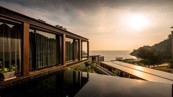 A modern building with a glass facade overlooking a body of water.