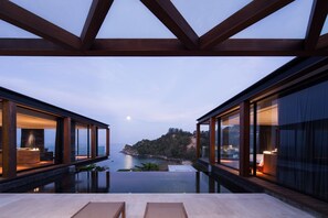 A modern infinity pool with a view of the sea and a distant island.