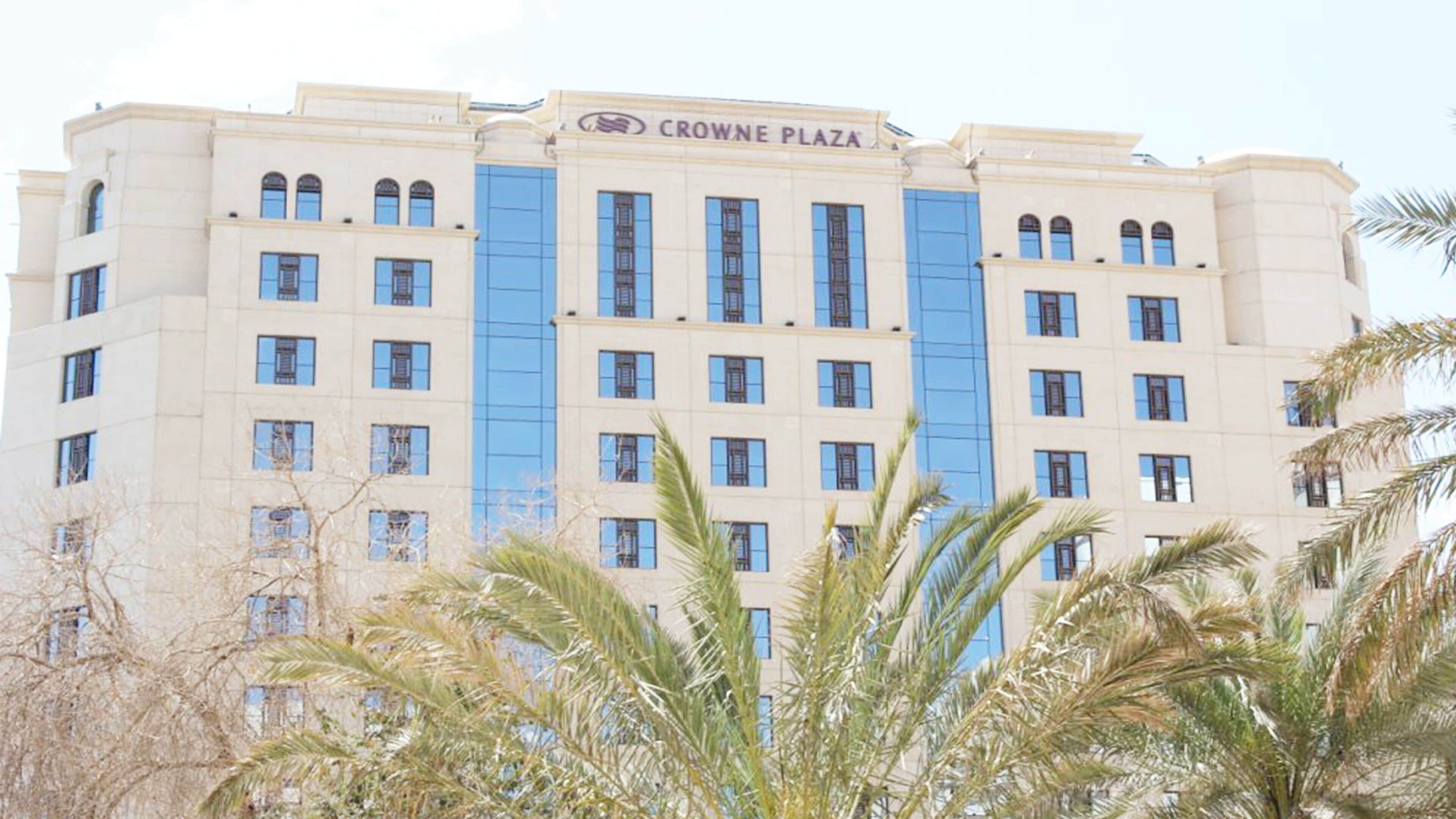 Un edificio a più piani con il cartello "CROWNE PLAZA" sulla sommità.