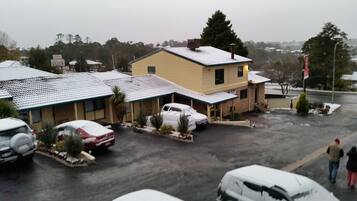 A motel with multiple rooms, a parking lot, and a snowy environment.