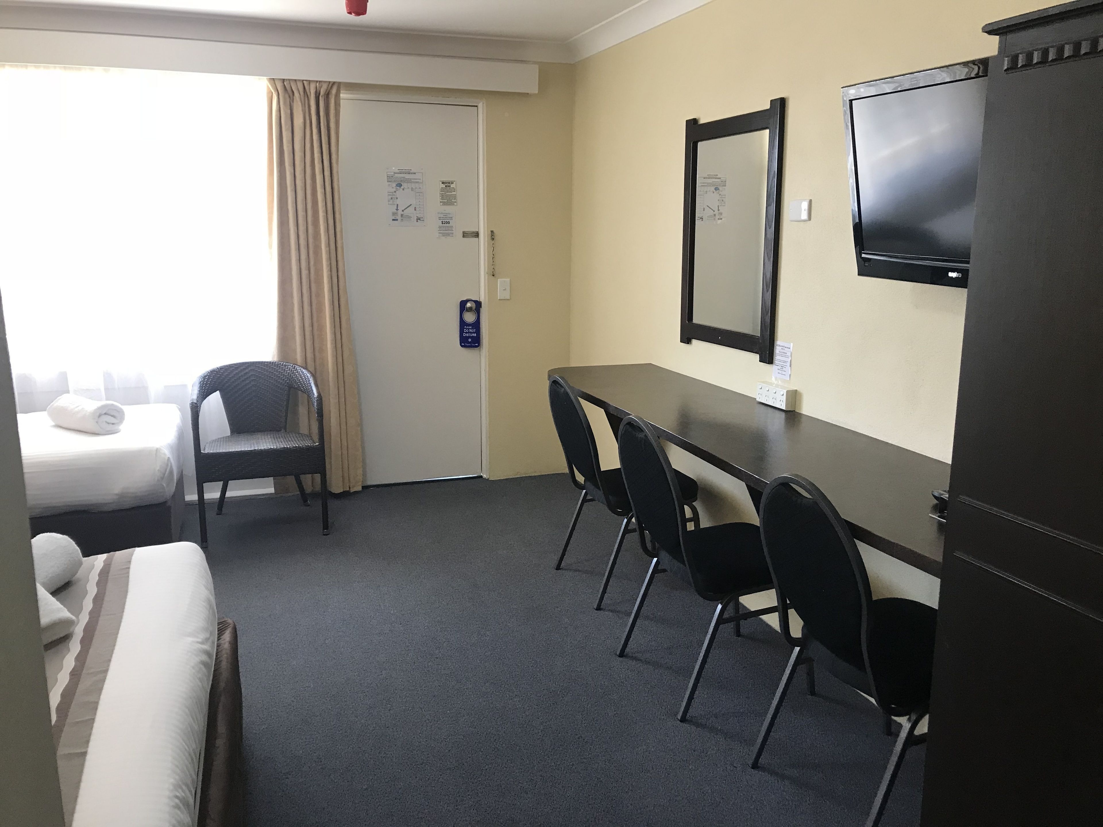 Une chambre d’hôtel avec un lit, une chaise, un bureau et un téléviseur.