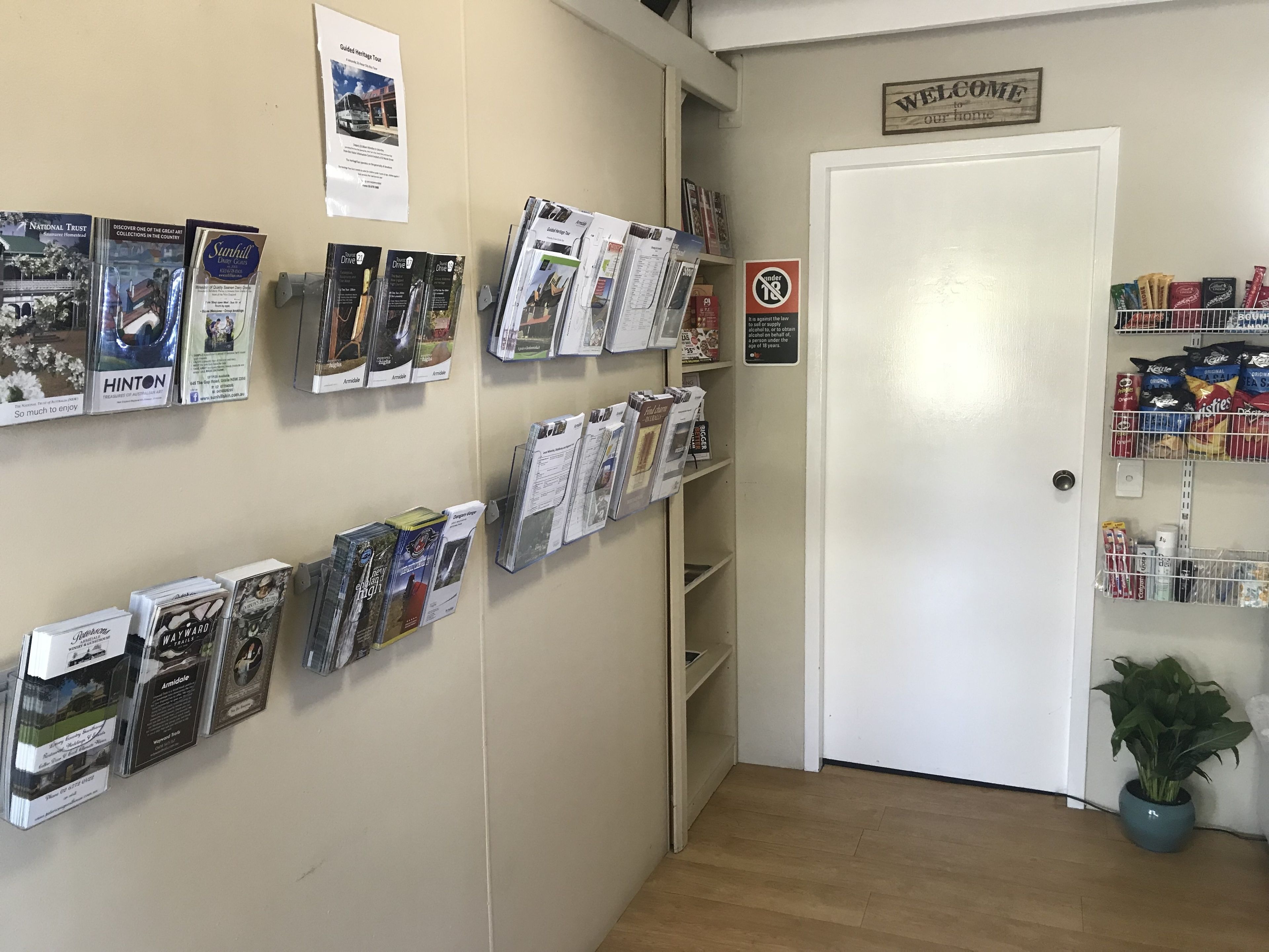 A reception area with a 'Welcome' sign, a 'No Smoking' sign, and a display of magazines and brochures.