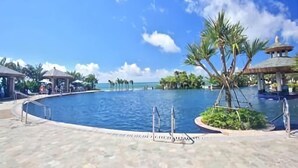 Una gran piscina con cielo azul despejado y palmeras.